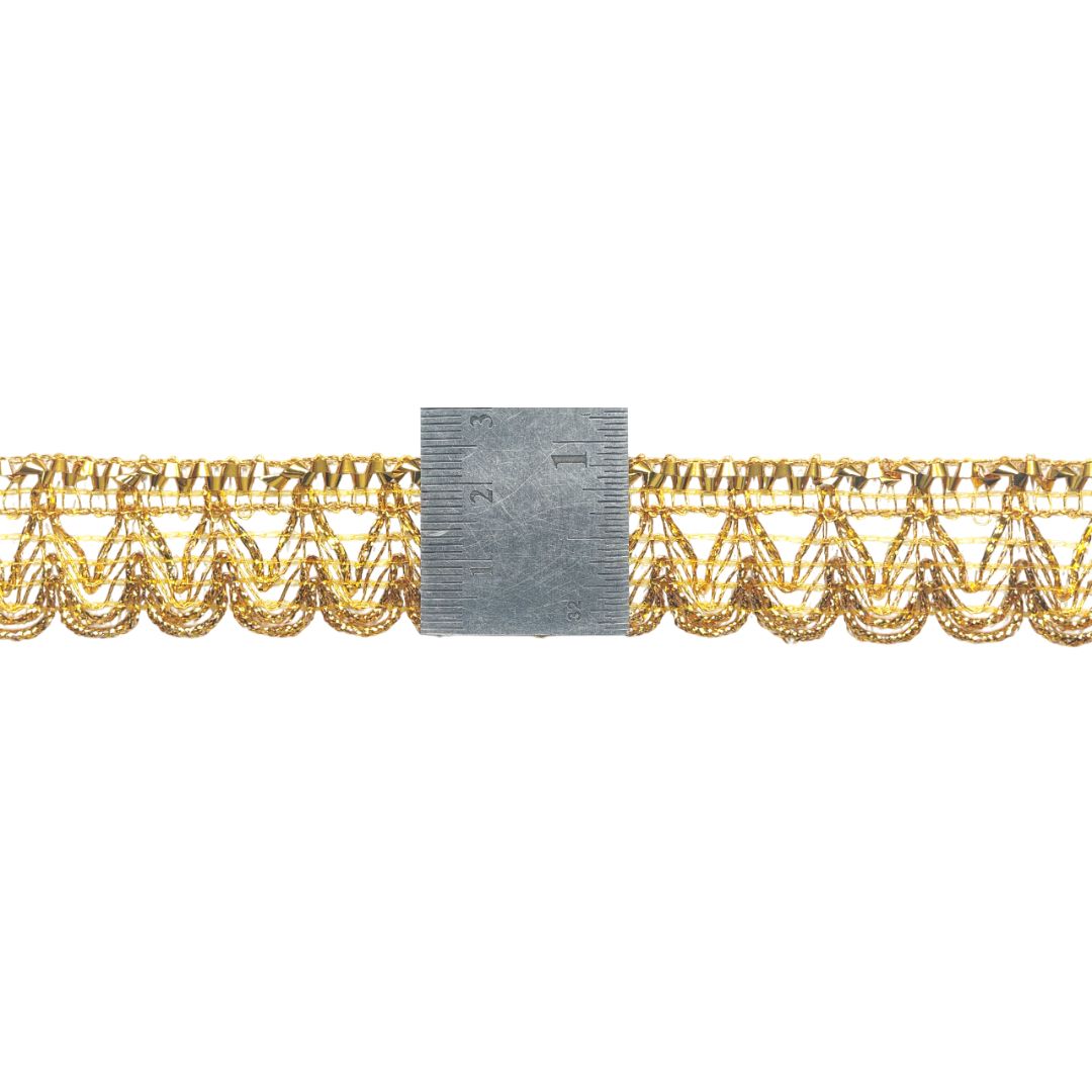 Gold lace trim with a ruler for scale on a white background